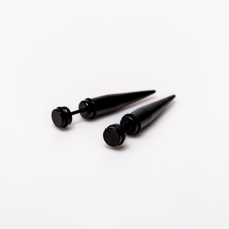 Black Spike - Earrings Dare to make a statement with our Black Spike Earrings. Crafted from high-quality alloy and painted in sleek black, these earrings are designed to mimic the look of actual gauges, adding a bold edge to your style. With a length of 1