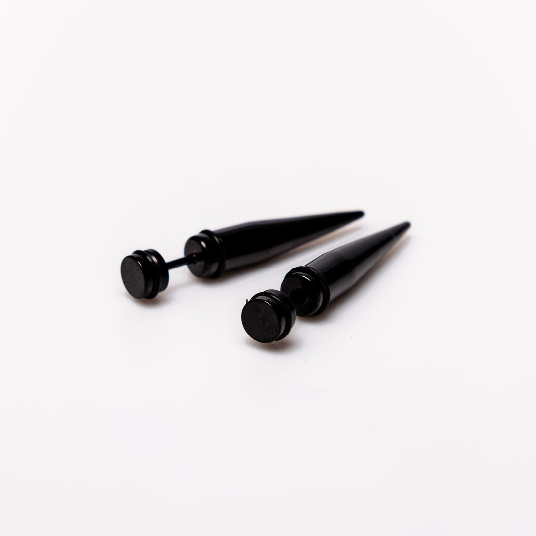 Black Spike - Earrings Dare to make a statement with our Black Spike Earrings. Crafted from high-quality alloy and painted in sleek black, these earrings are designed to mimic the look of actual gauges, adding a bold edge to your style. With a length of 1