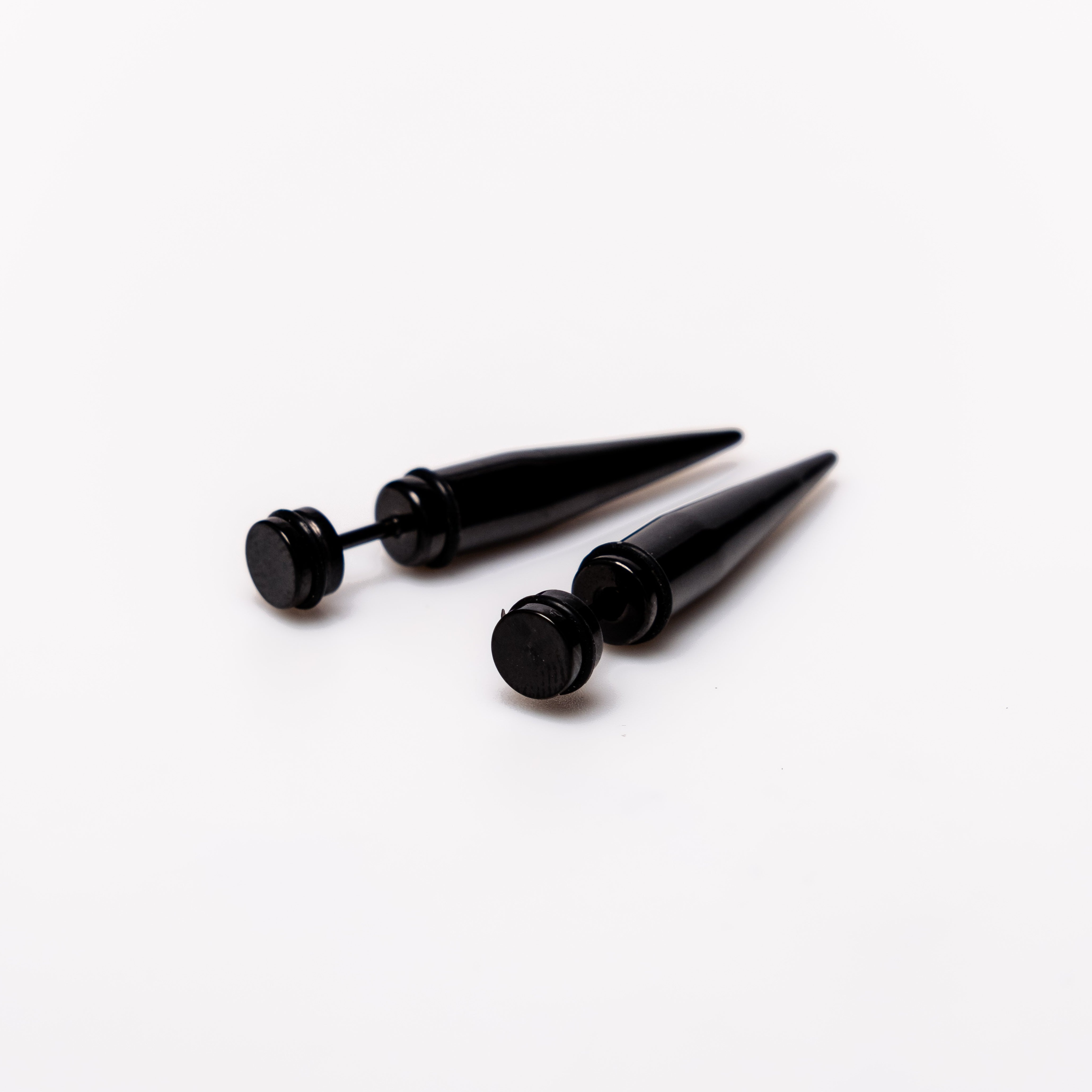 Black Spike - Earrings Dare to make a statement with our Black Spike Earrings. Crafted from high-quality alloy and painted in sleek black, these earrings are designed to mimic the look of actual gauges, adding a bold edge to your style. With a length of 1
