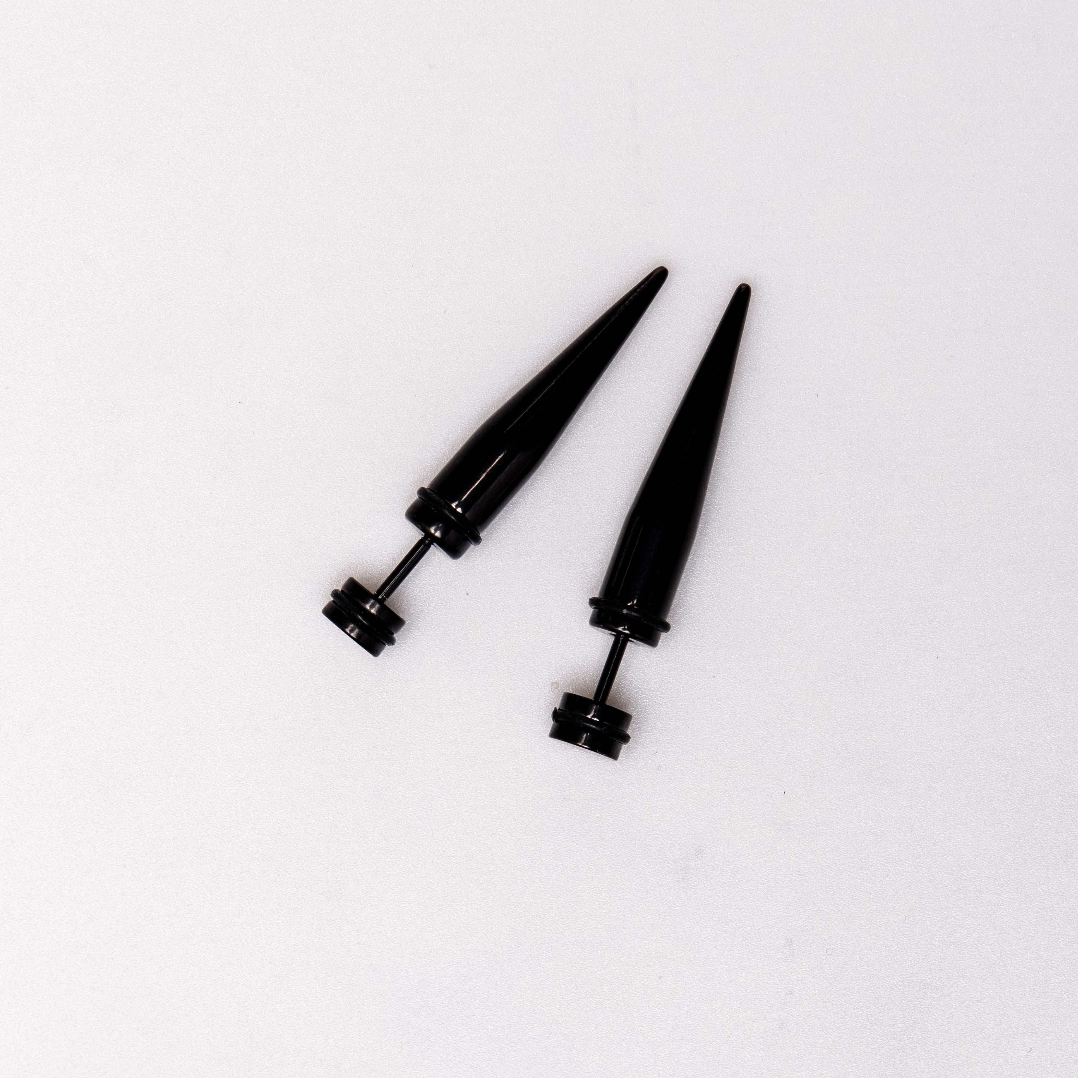 Black Spike - Earrings Dare to make a statement with our Black Spike Earrings. Crafted from high-quality alloy and painted in sleek black, these earrings are designed to mimic the look of actual gauges, adding a bold edge to your style. With a length of 1