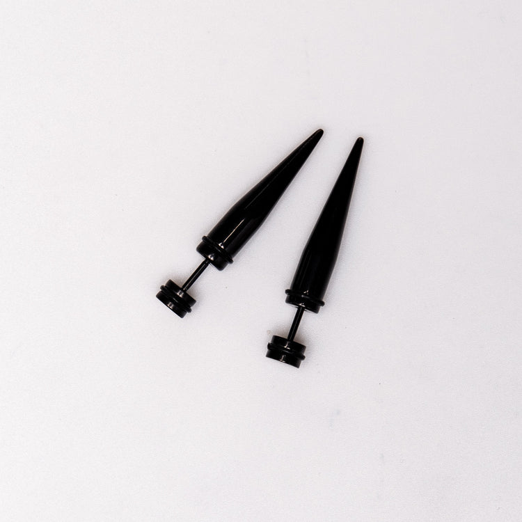Black Spike - Earrings Dare to make a statement with our Black Spike Earrings. Crafted from high-quality alloy and painted in sleek black, these earrings are designed to mimic the look of actual gauges, adding a bold edge to your style. With a length of 1